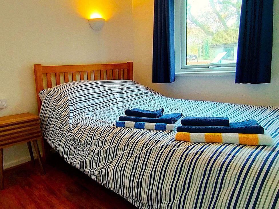A bedroom with a bed and towels on it at Painters Cottage 2Bed Chalet Free Leisure Passes Near St Ives