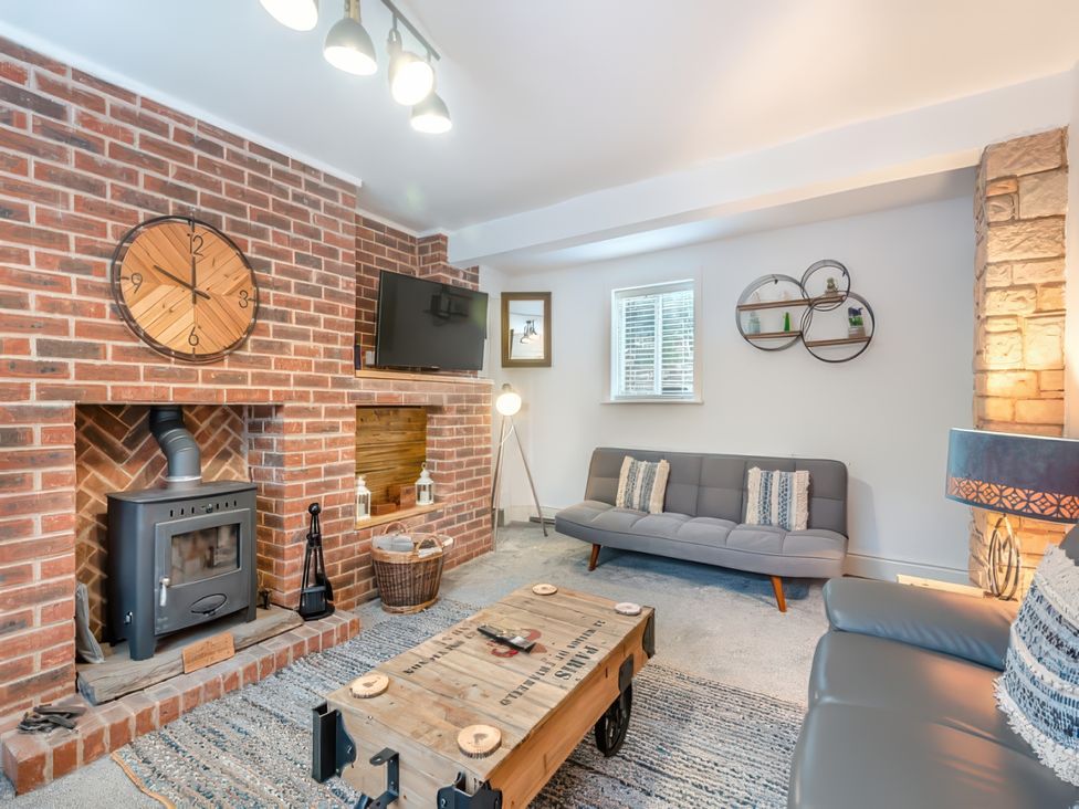 A living room with a fireplace and sofa at The Old Barn in Manchester