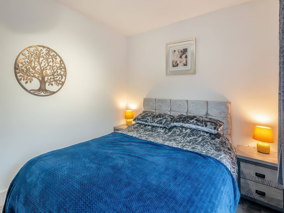 A bedroom with a bed and nightstands at The Old Barn in Manchester