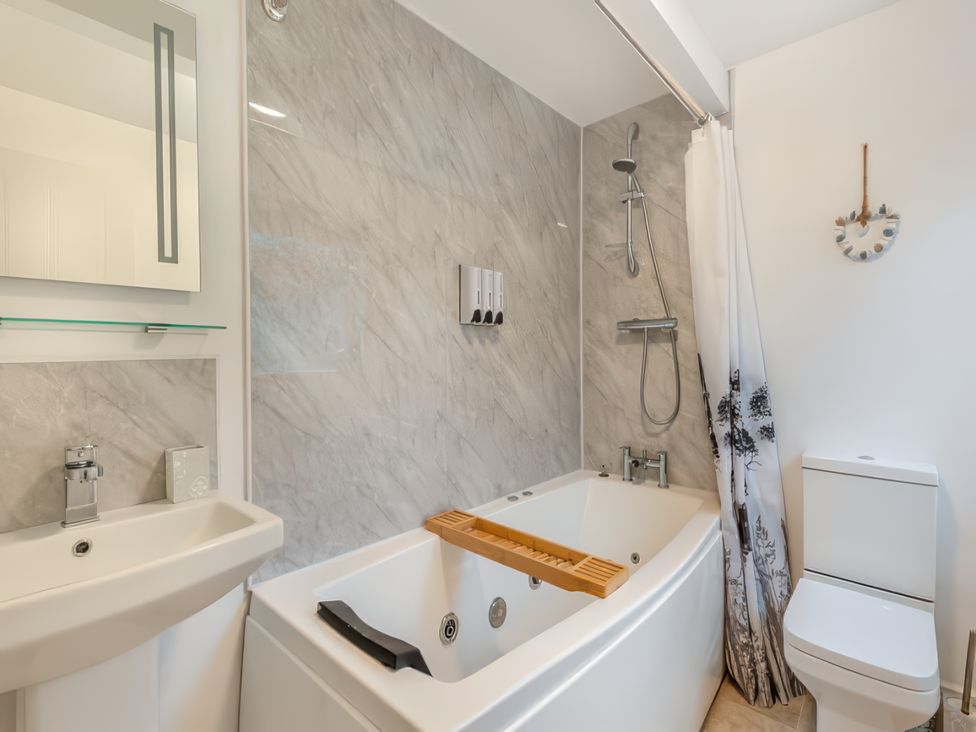 A bathroom with a bathtub, shower, sink and toilet at 