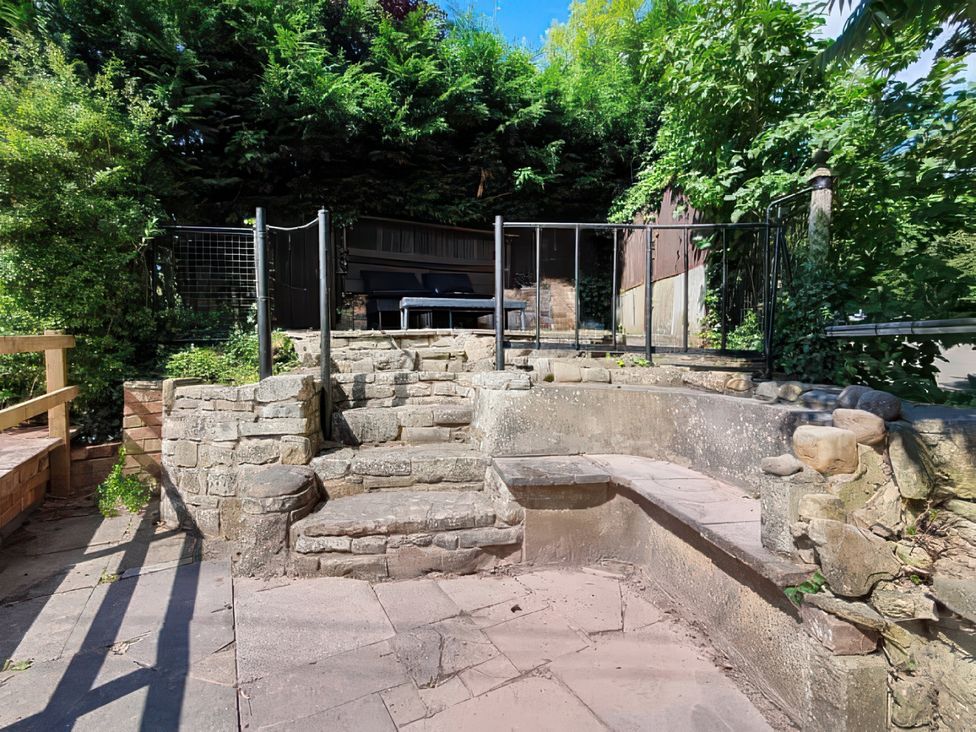 A garden area with stone steps and a bench at the property