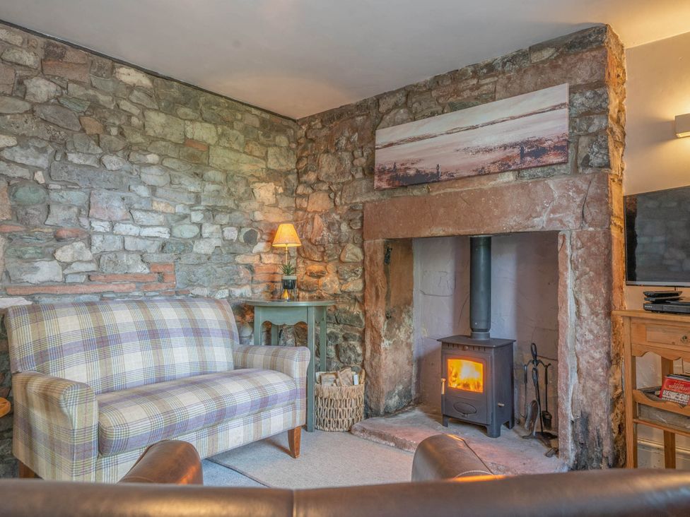 A living room with a sofa and fireplace at Cosy cottage near scenic walks and country pub in Penrith