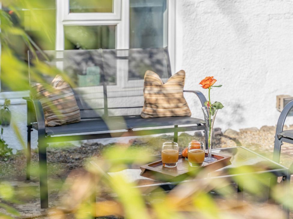 An outdoor seating area with sofa and drinks at Cosy cottage near scenic walks and country pub, Penrith