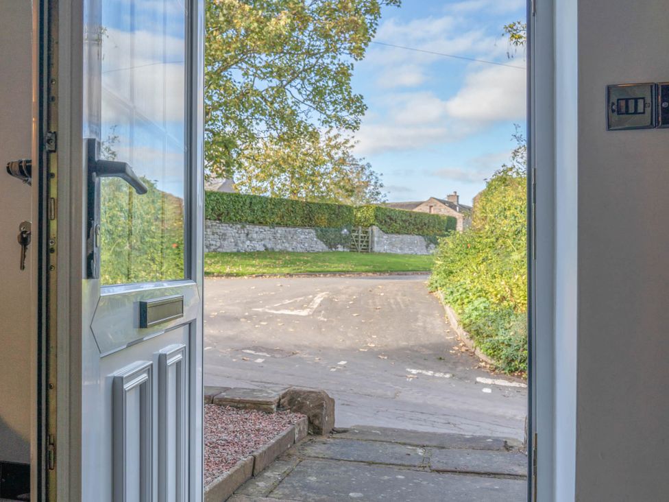 A view from a door looking onto a path and greenery at Cosy cottage near scenic walks and country pub in Penrith