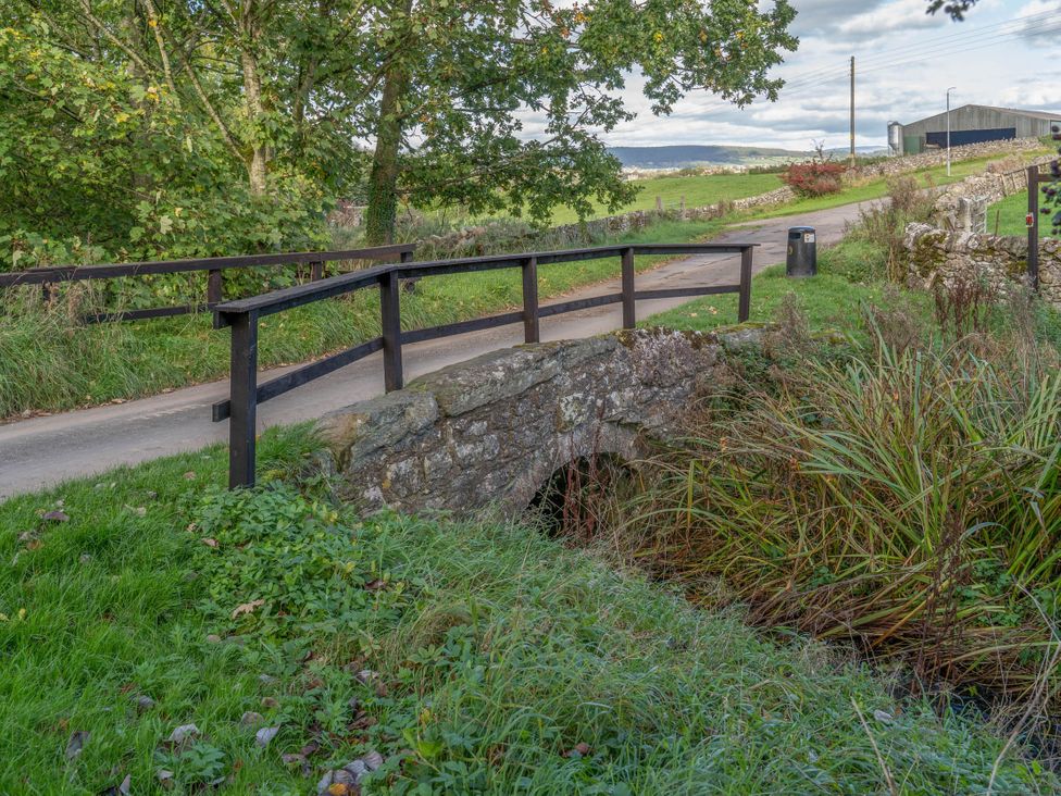 A bridge over a stream beside a path at Cosy cottage near scenic walks and country pub Penrith