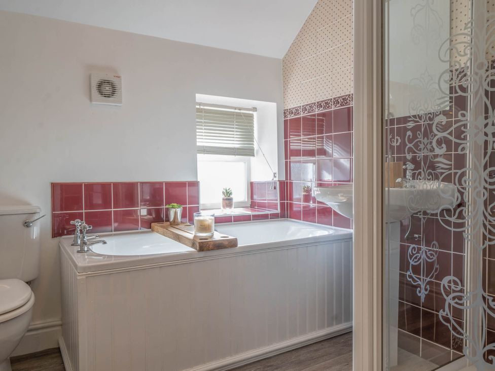 A bathroom with a bathtub and shower at Cosy cottage near scenic walks and country pub, Penrith