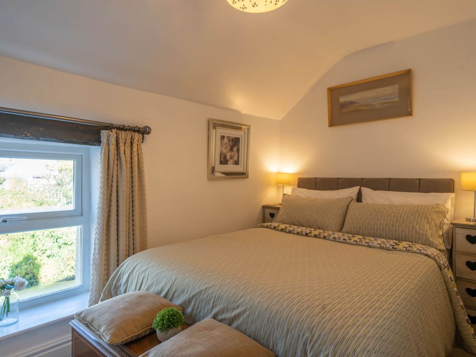 A bedroom with a bed and lamps at Cosy cottage near scenic walks and country pub, Penrith