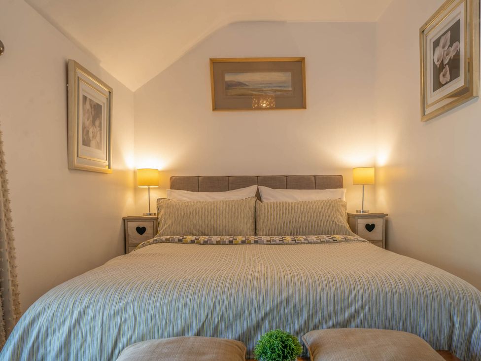 A bedroom with a bed and bedside tables at Cosy cottage near scenic walks and country pub in Penrith