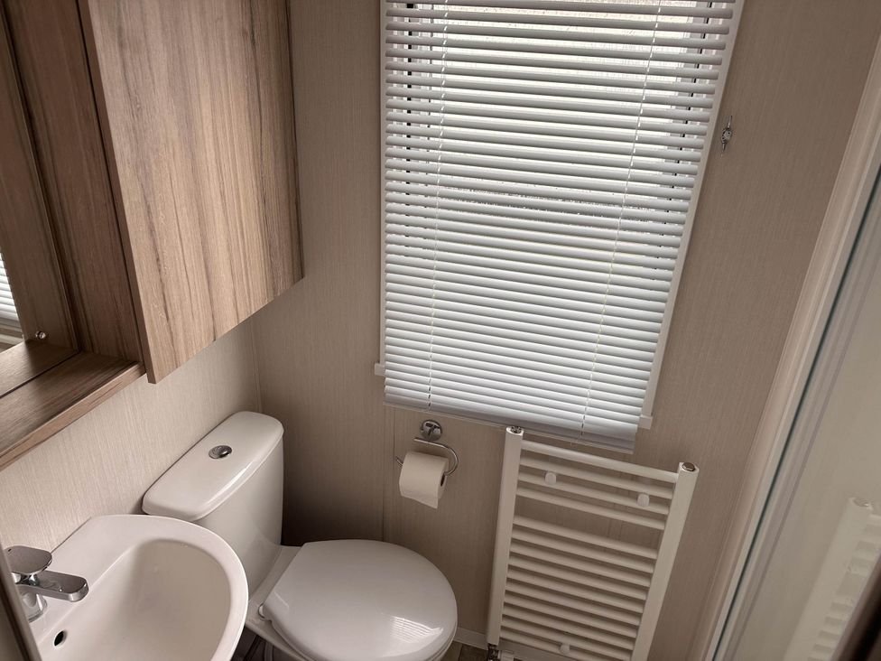 A bathroom with a toilet and sink at R&R Coastal Retreats Cedars 63 Skegness