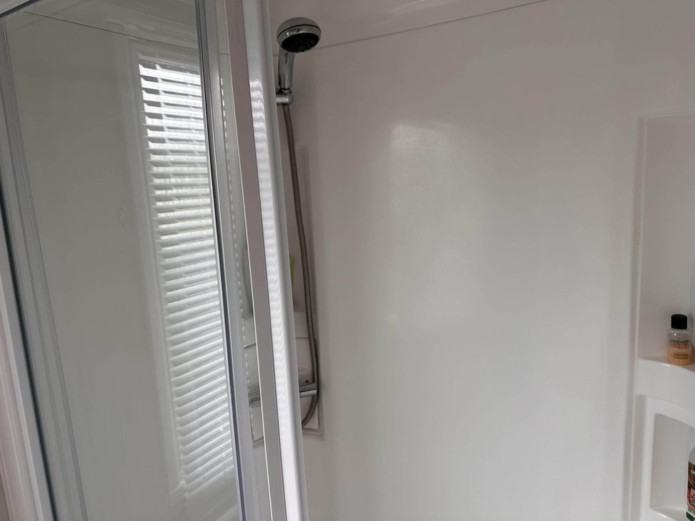 A bathroom with a shower and a bottle on a shelf at R&R Coastal Retreats Cedars 63 Skegness