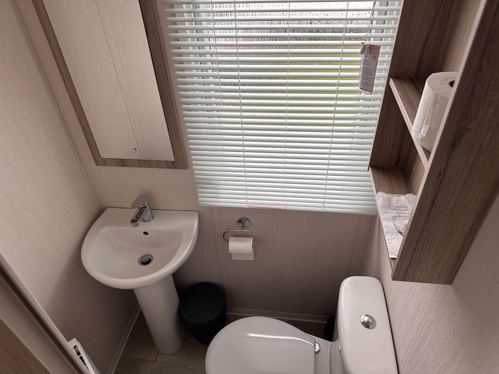 A bathroom with a sink and toilet at R&R Coastal Retreats Cedars 63 Skegness