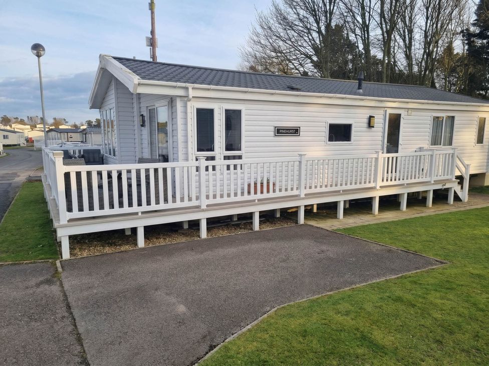 A mobile home with deck and parking area at Cayton Bay Lodge Parkdean Resorts, Scarborough
