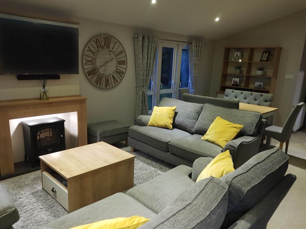 A living room with a sofa and television at Cayton Bay Lodge Parkdean Resorts, Scarborough