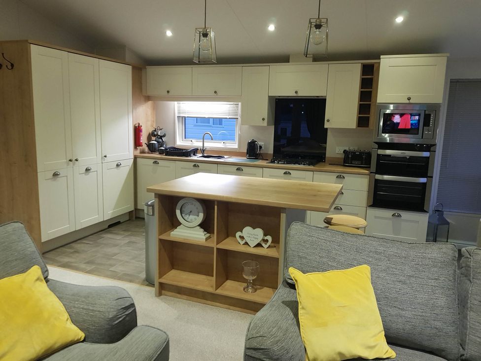 A kitchen with cabinets and appliances at Cayton Bay Lodge Parkdean Resorts Scarborough