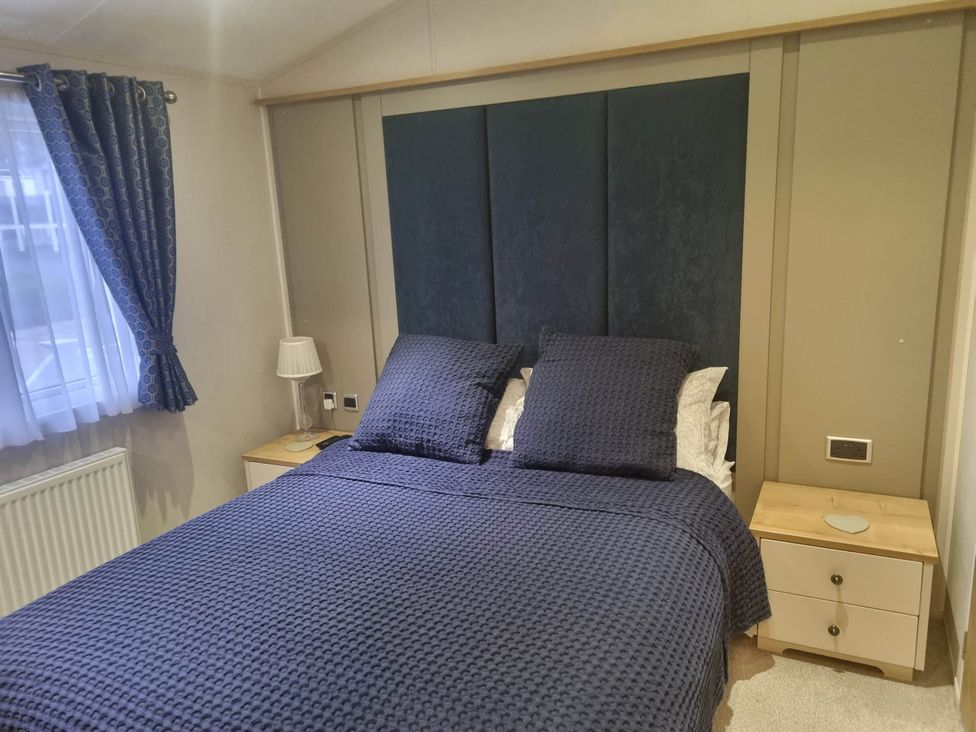 A bedroom with a bed and bedside table at Cayton Bay Lodge Parkdean Resorts Scarborough