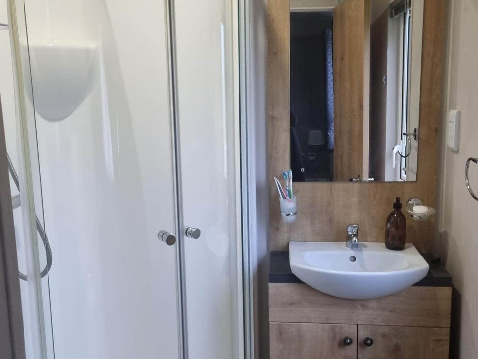 A bathroom with a shower and a washbasin at Cayton Bay Lodge Parkdean Resorts, Scarborough