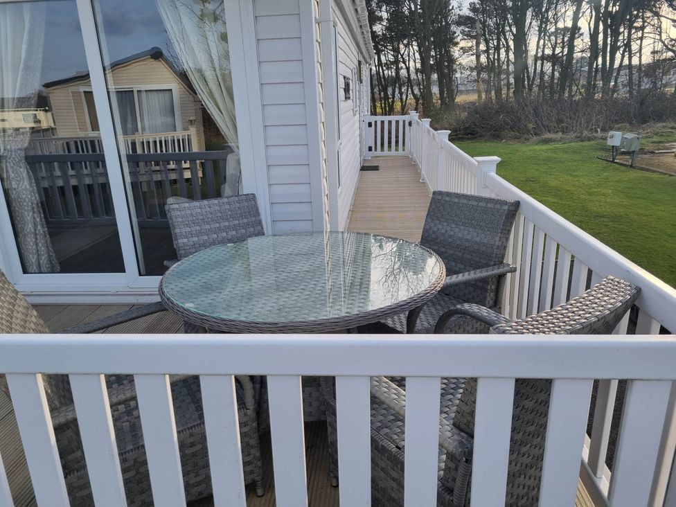 A deck with a table and chairs at Cayton Bay Lodge Parkdean Resorts in Scarborough