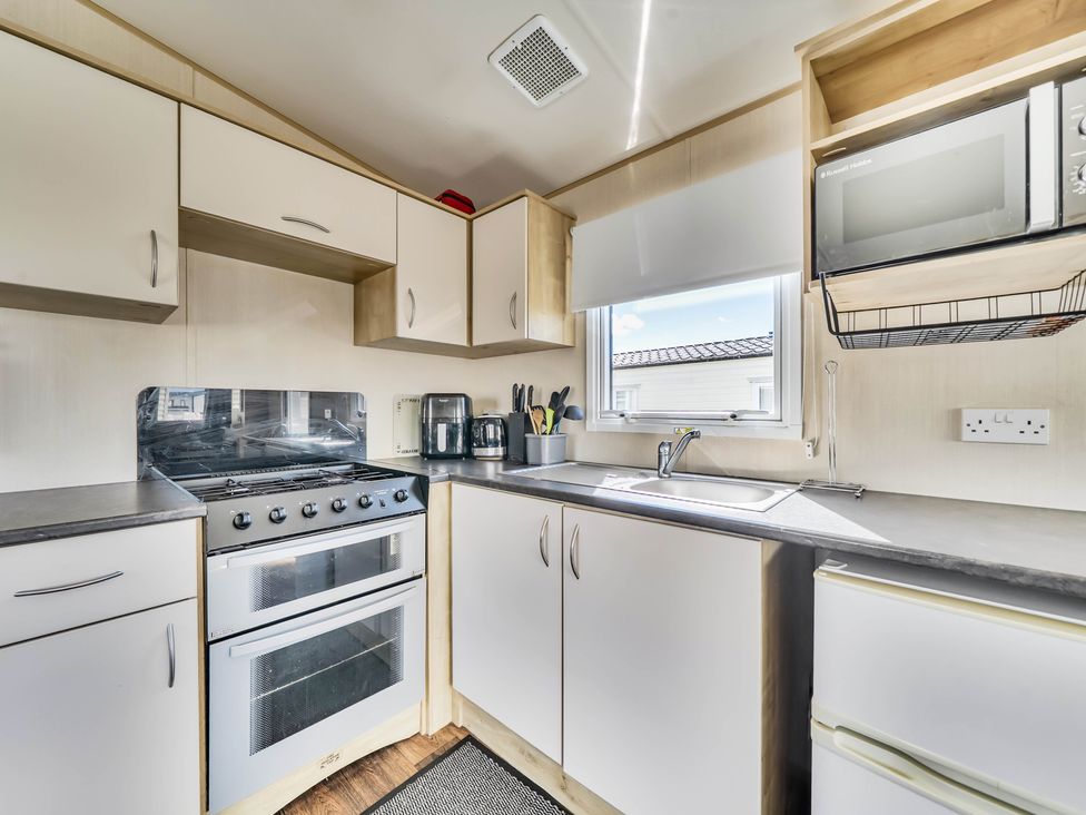 A kitchen with sink and oven at Sleeps 8 Communal Spa Access Parking in Rhyl