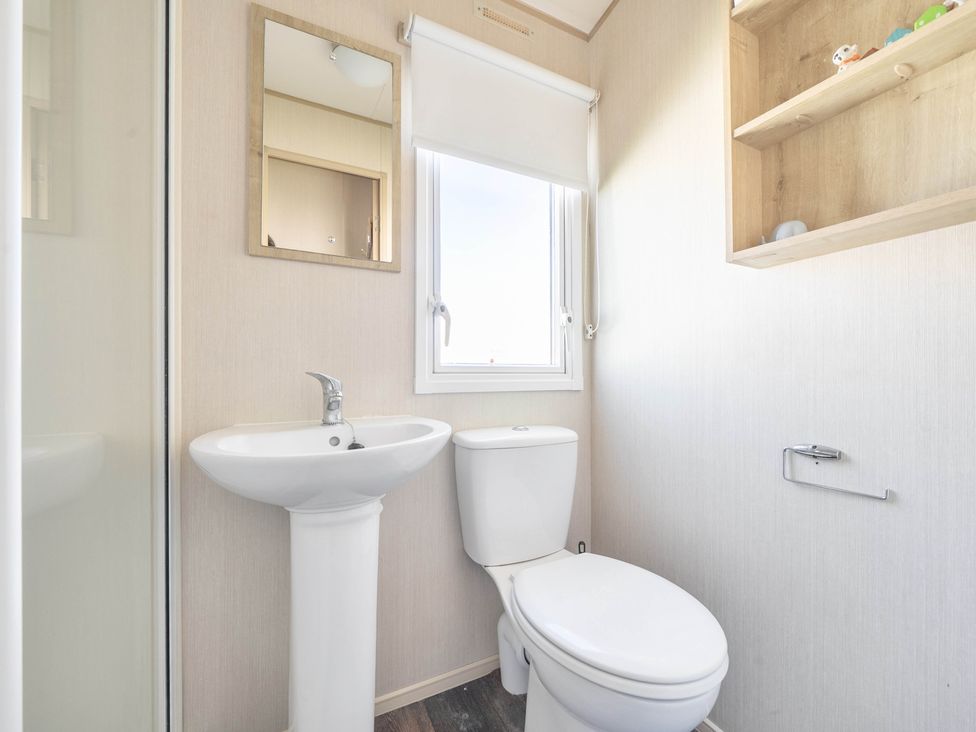 A bathroom with a sink and toilet at Sleeps 8 Communal Spa Access Parking Rhyl