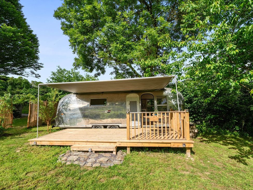 A trailer on a wooden deck in a garden at Sleeps 2 - Private Hot Tub - Fire Pit, St. Dogmaels near Cardigan
