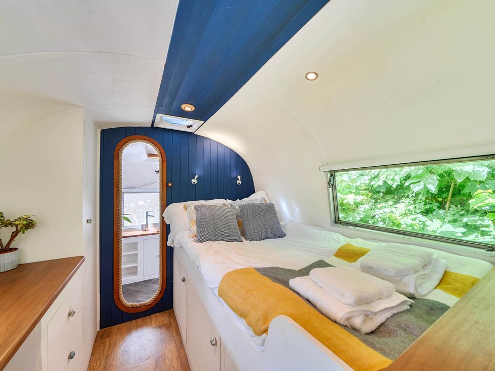 A bedroom with a bed and mirror at Sleeps 2 - Private Hot Tub - Fire Pit in St. Dogmaels near Cardigan