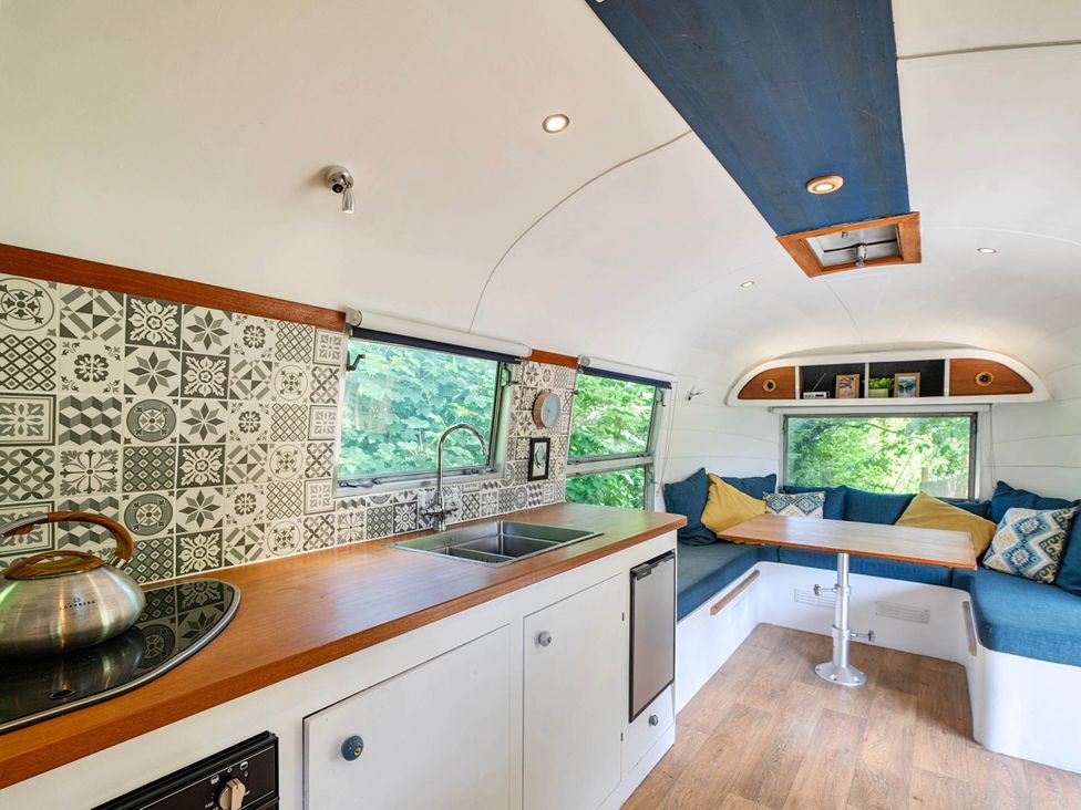 A living area with a kitchen and seating area at Sleeps 2 - Private Hot Tub - Fire Pit, St. Dogmaels near Cardigan