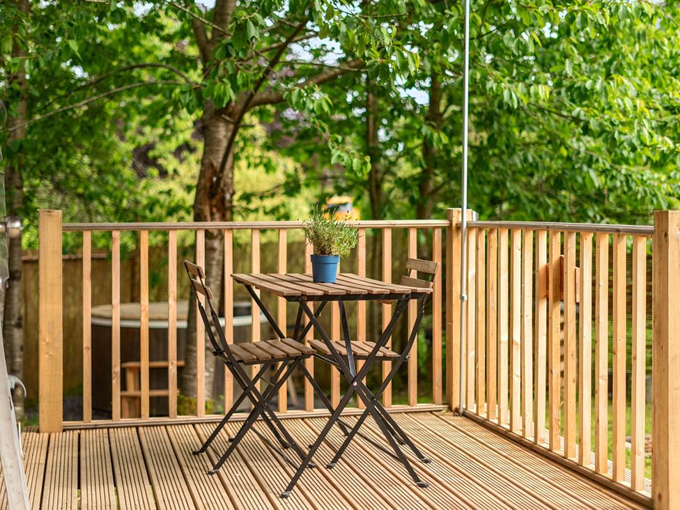 A patio with a table and chairs and plants at Sleeps 2 - Private Hot Tub - Fire Pit, St. Dogmaels near Cardigan