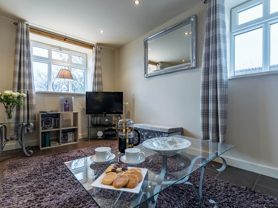A living room with a table and coffee cups at The Old Barn in Manchester