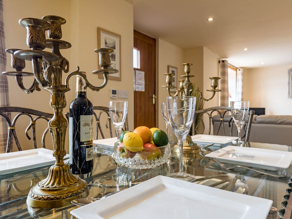 A dining table with a candelabra, wine bottle, and fruit bowl at The Old Barn in Manchester