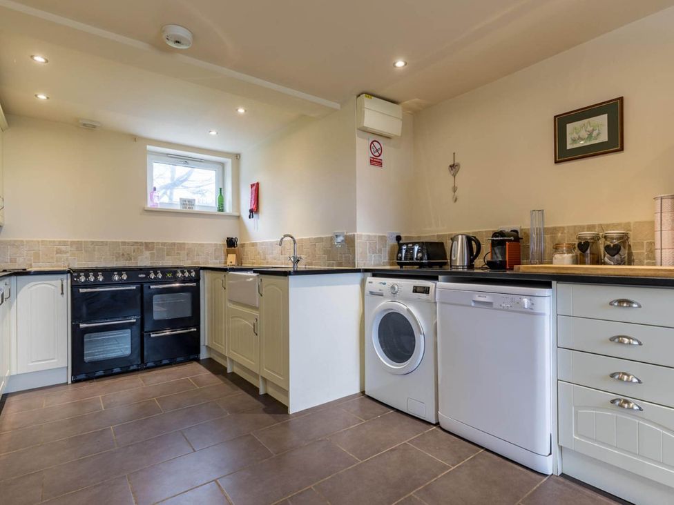 A kitchen with oven and washing machine at The Old Barn in Manchester