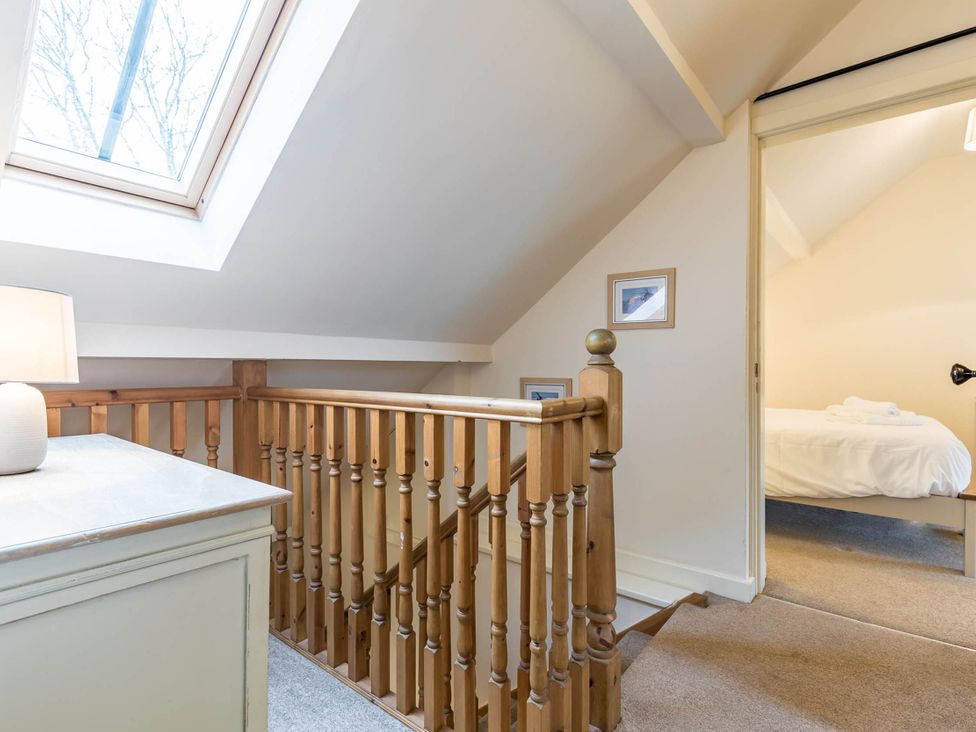 A landing with a staircase and a skylight at a property