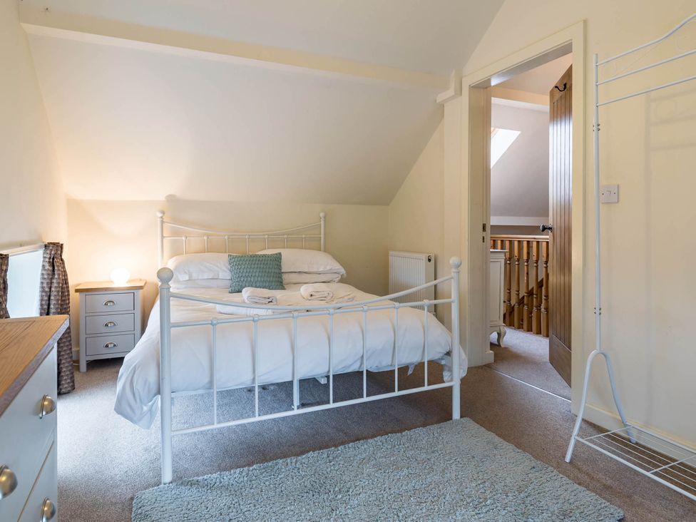 A bedroom with a bed and nightstand at The Old Barn in Manchester