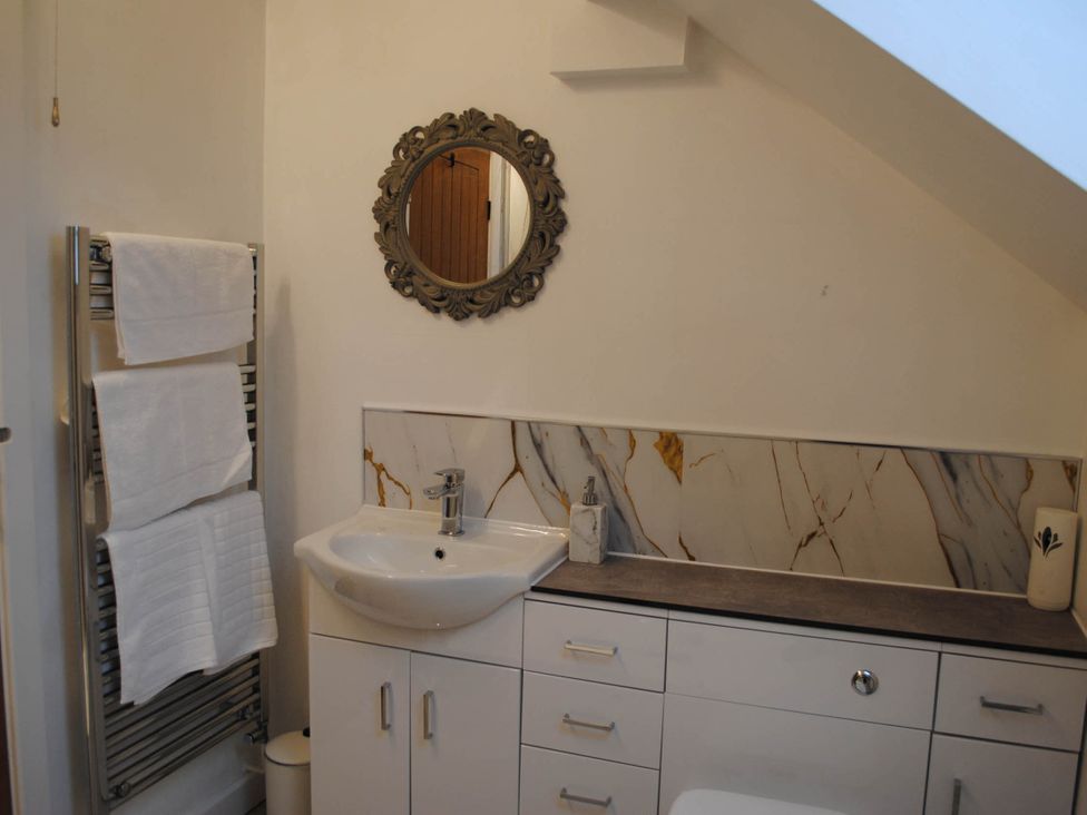 A bathroom with a sink, towel rack, and mirror at a property