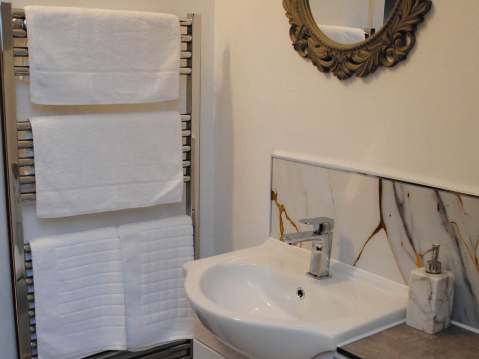 A bathroom with a sink, towels on a rack, and a mirror at the property