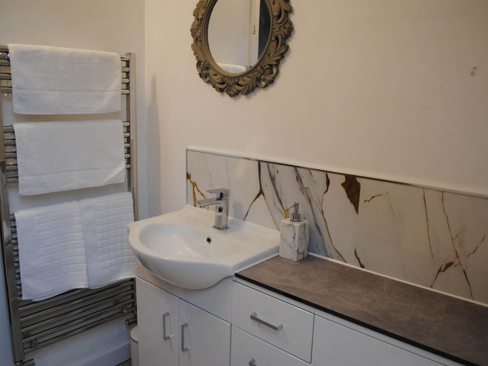 A bathroom featuring a sink, mirror, and towel rack with towels at the property in 