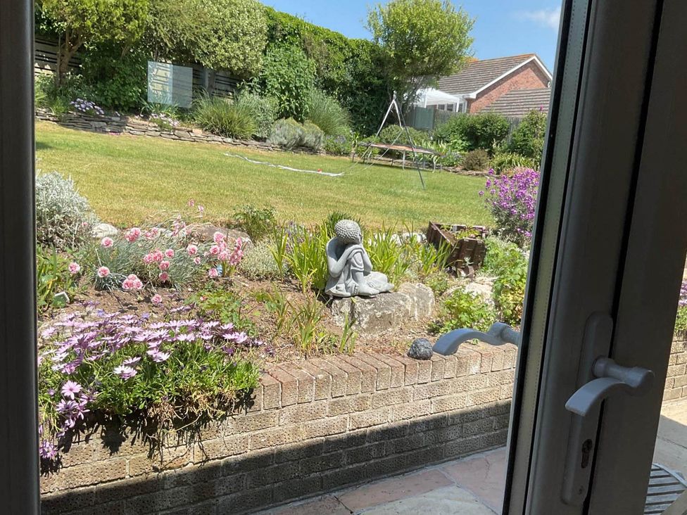 A garden with flowers and a statue at Bungalow Sleeps 2  Parking in Newquay