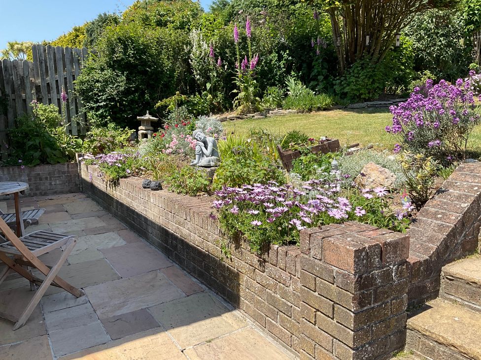 A garden with flowers and a statue at Bungalow Sleeps 2 Parking in Newquay