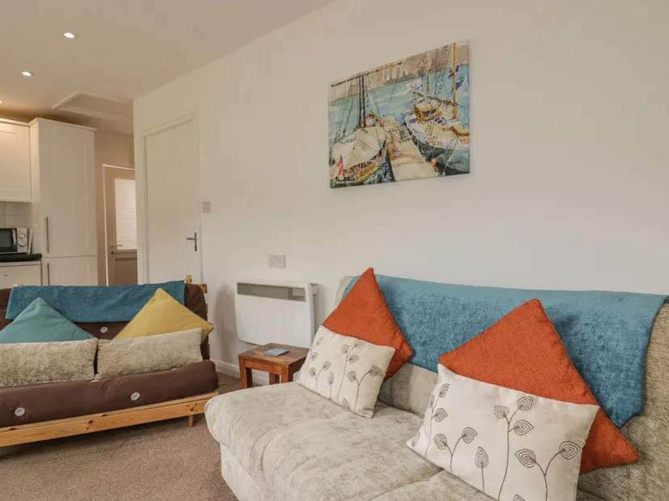 A living room with a sofa and cushions at Bungalow Sleeps 2 Parking in Newquay