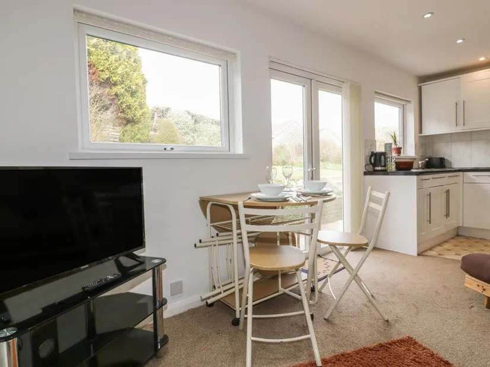 A kitchen with table and chairs at Bungalow Sleeps 2 Parking Newquay