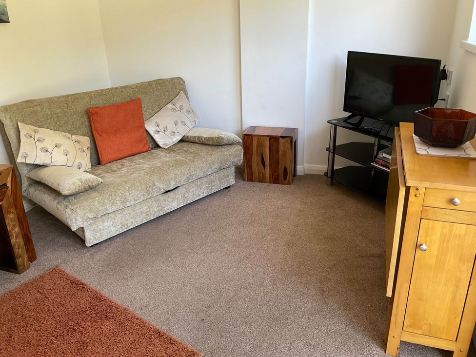 A living room with a sofa and television at Bungalow Sleeps 2 Parking in Newquay