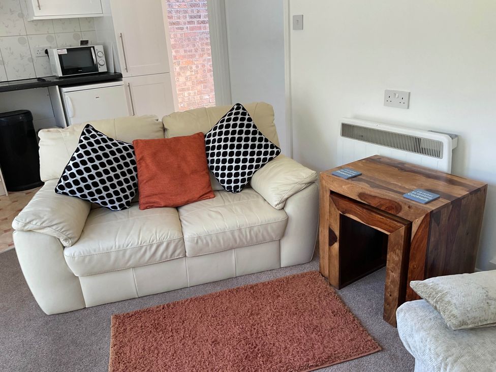 A living room with a sofa and table at Bungalow Sleeps 2 Parking Newquay