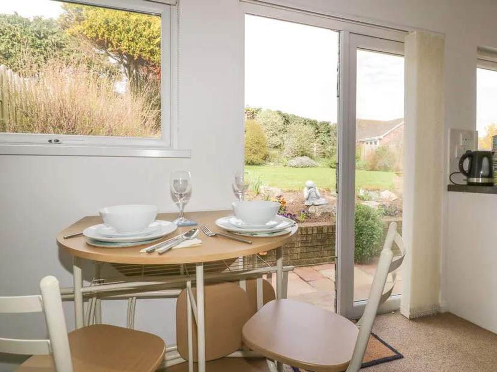A dining area with a table set for two at Bungalow Sleeps 2 Parking in Newquay