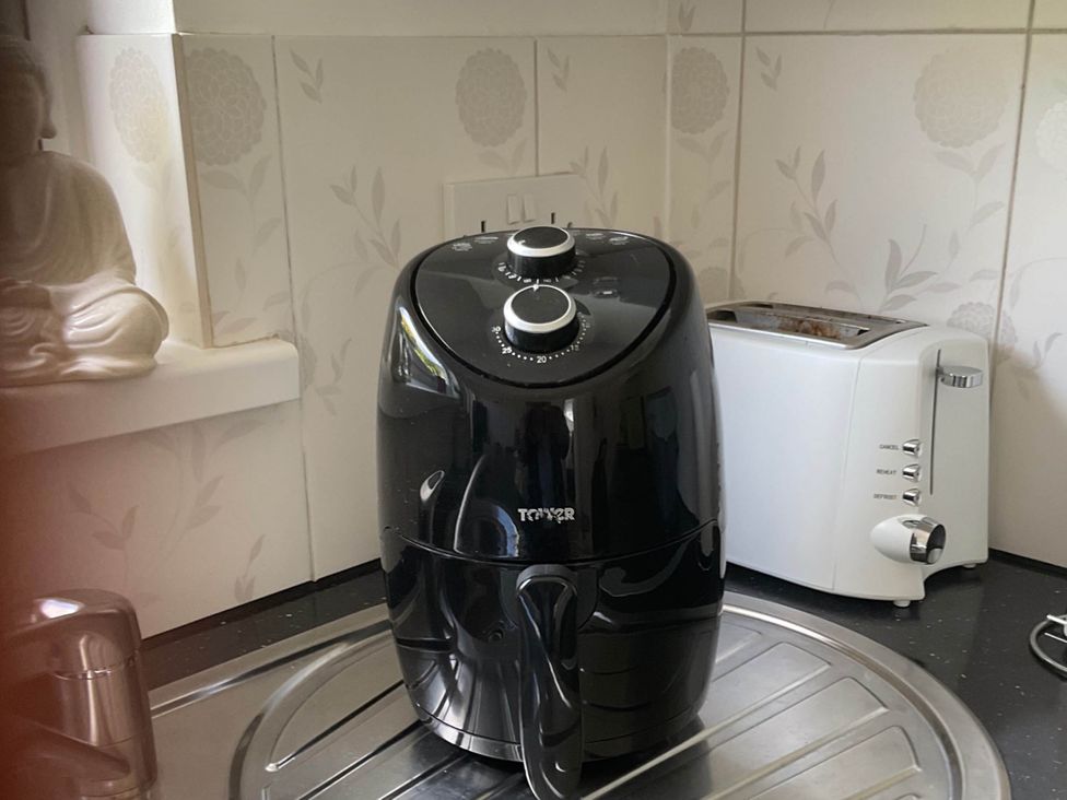 An air fryer and toaster on a countertop in a kitchen with a sink at Bungalow Sleeps 2 Parking Newquay