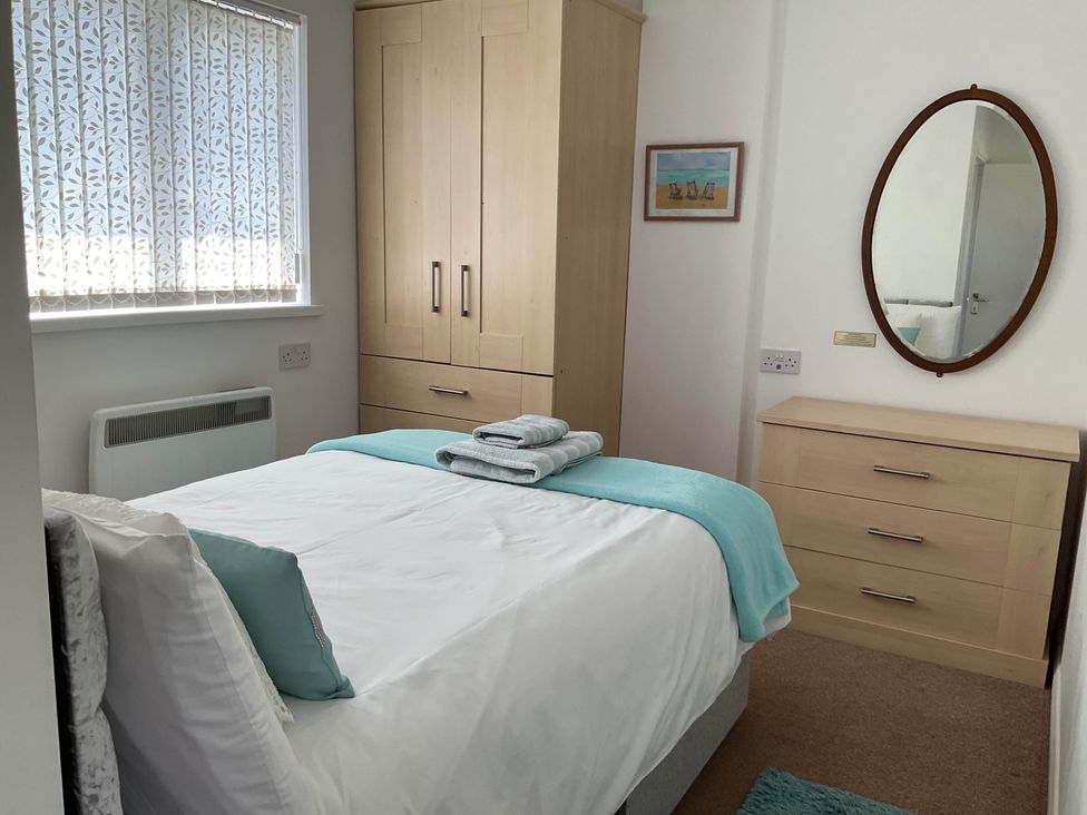 A bedroom with a bed and wardrobe at Bungalow Sleeps 2 Parking in Newquay