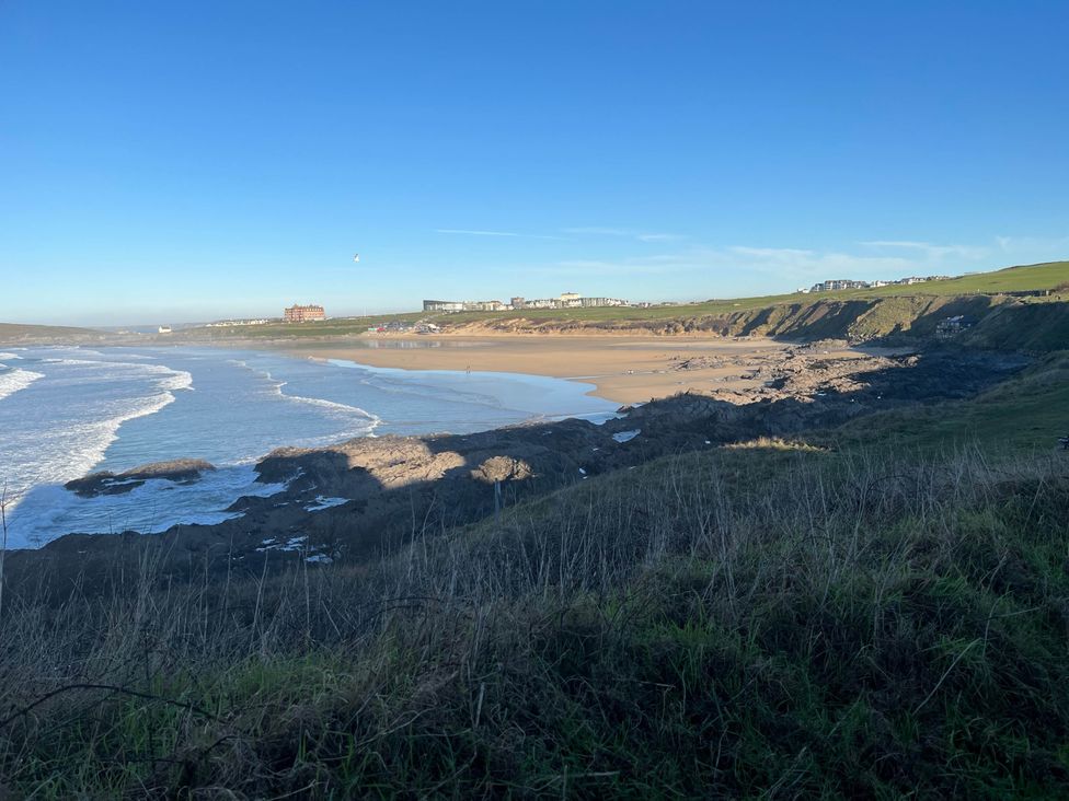 A beach with waves and cliffs at Bungalow Sleeps 2 Parking in Newquay
