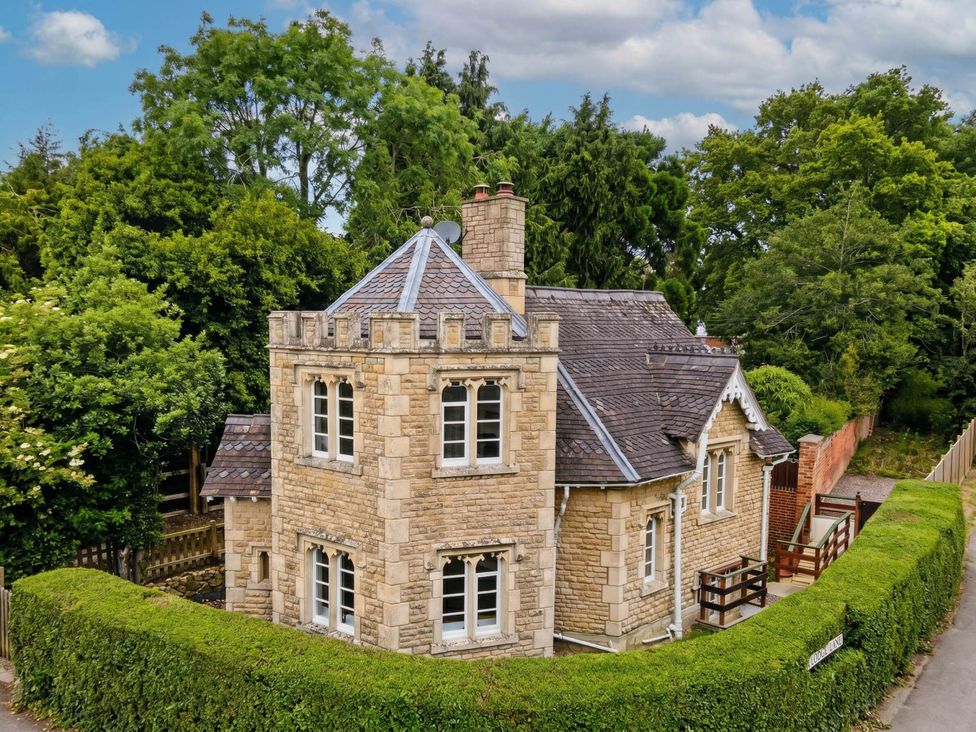 An exterior view of a stone house surrounded by trees at Cotswolds Castle Sleeps 8 with Enclosed Garden, Banbury