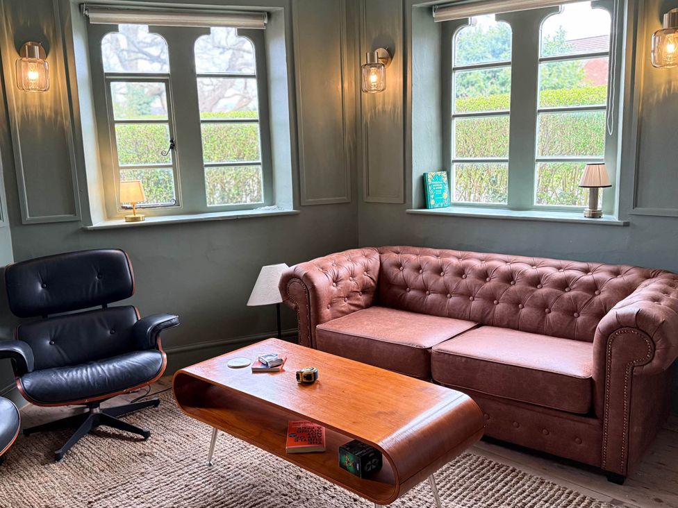A living room with a sofa and coffee table at Cotswolds Castle Sleeps 8 with Enclosed Garden in Banbury