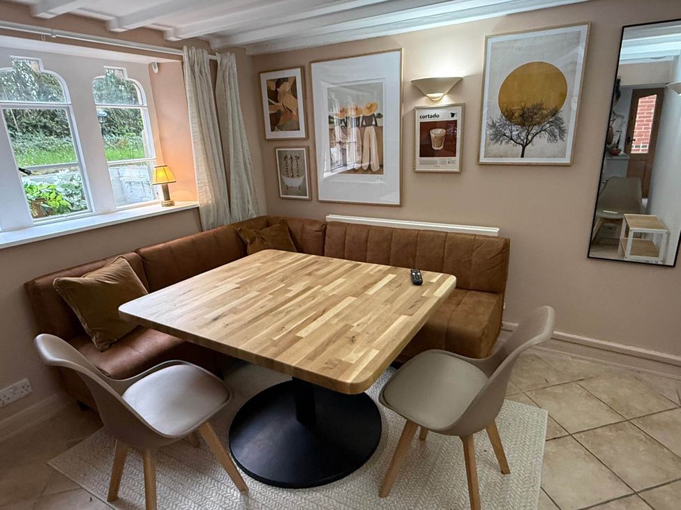 A dining room with a wooden table and chairs at Cotswolds Castle Sleeps 8 with Enclosed Garden in Banbury