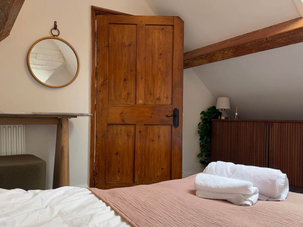 A bedroom with towels on a bed at Cotswolds Castle Sleeps 8 with Enclosed Garden in Banbury