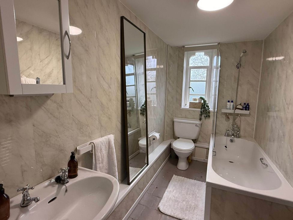 A bathroom with sink and bathtub at Cotswolds Castle Sleeps 8 with Enclosed Garden, Banbury